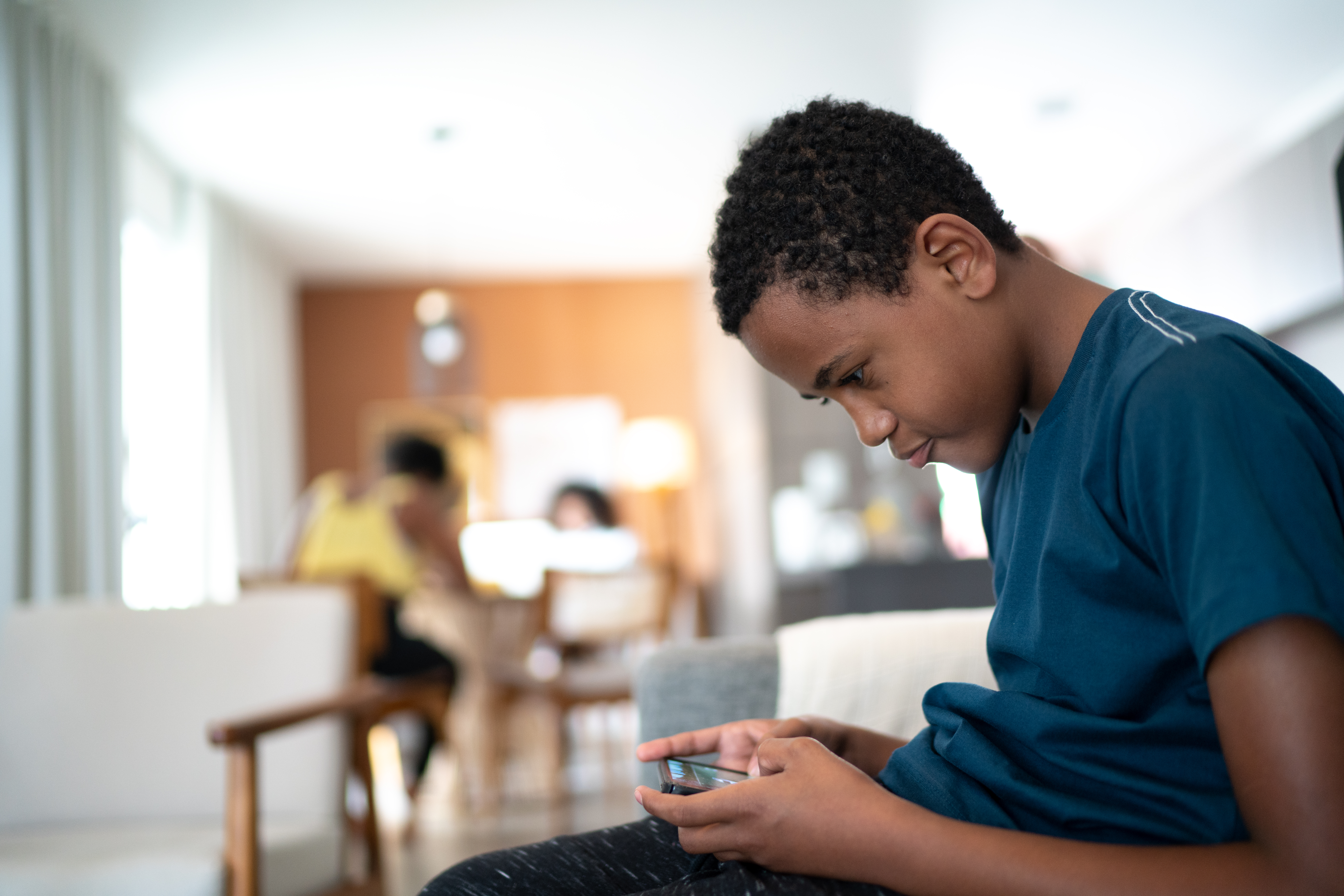 Teenager boy using smartphone at home